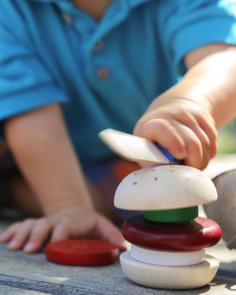 Kind met hamburger houten speelgoed van Selecta