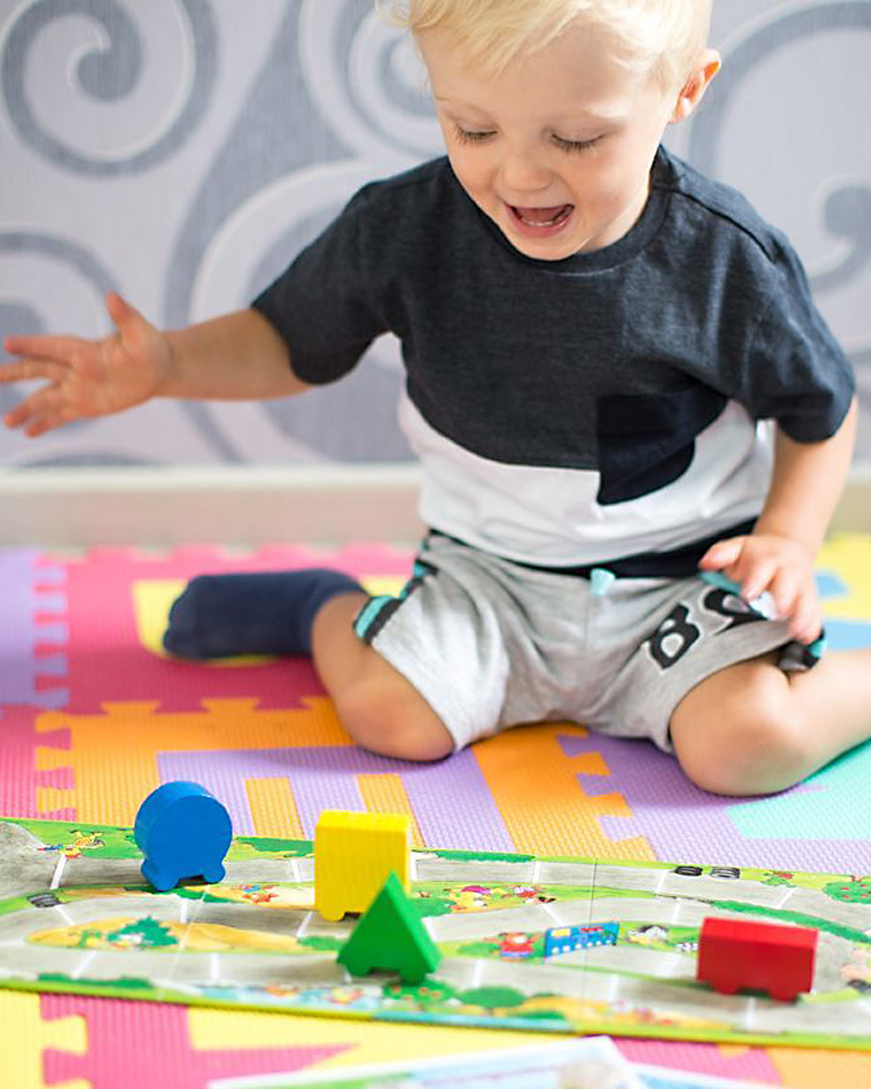 Kind met kakalbonte autorally houten speelgoed van Selecta