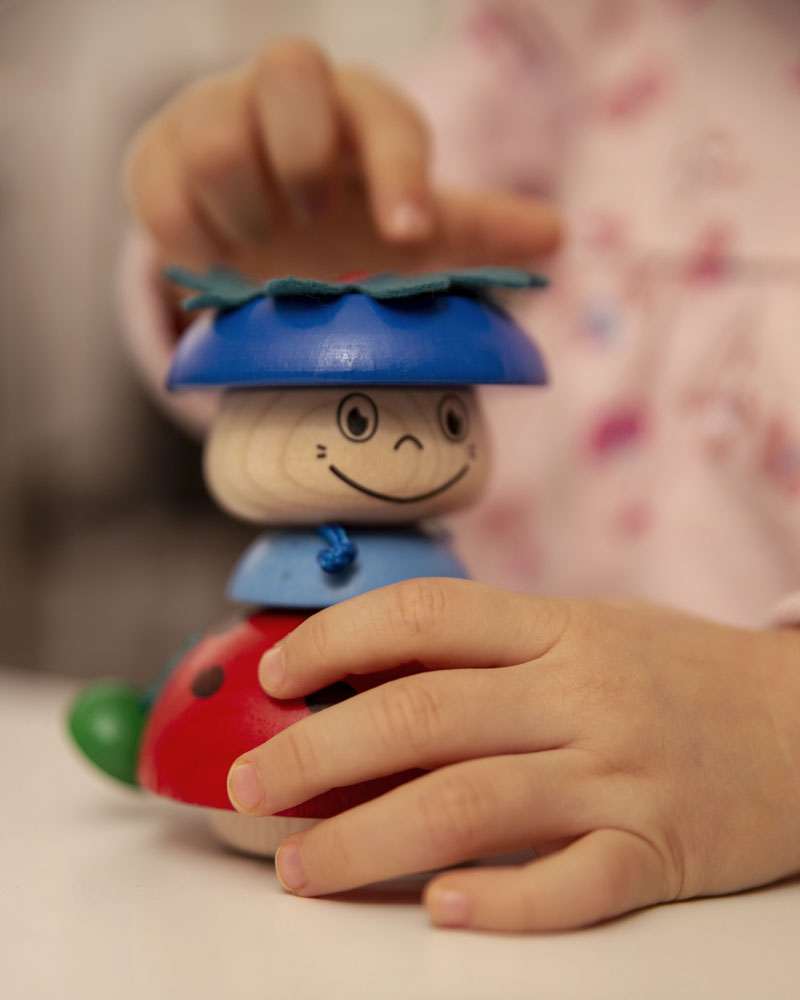 Kind met Stapelkapoentje Kalle houten speelgoed van selecta